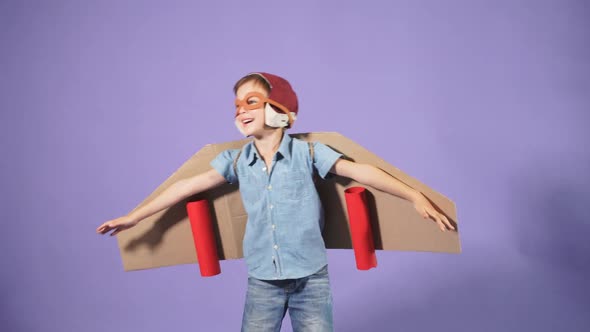 Pilot Boy with Cardboard Plane Isolated Over Blue Background
