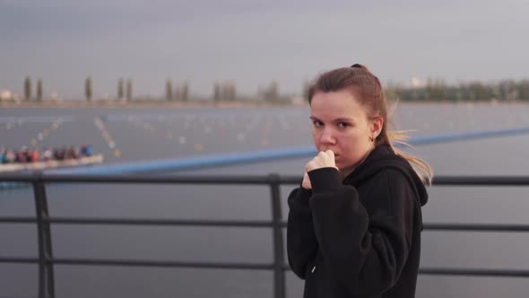 Female Boxer Jumps Looks at the Camera and Delivers a Straight Punch