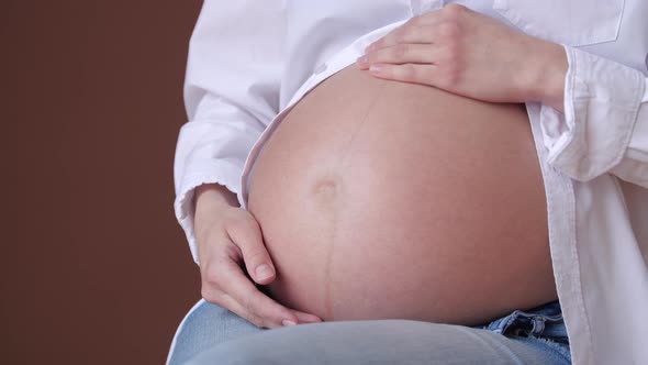 Young Pregnant Woman Stroking Her Belly Closeup