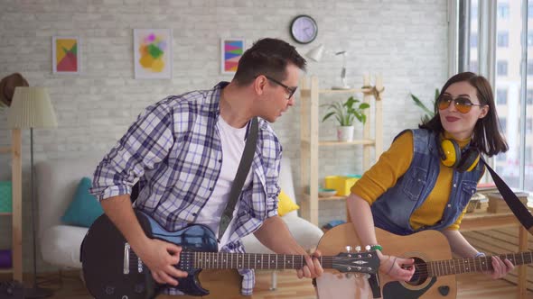 Portrait Young Woman and a Young Man Emotionally Play Guitars and Dance