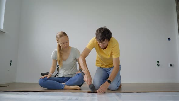 A Family of Woman and Man Install Laminate on the Floor in Their Apartment