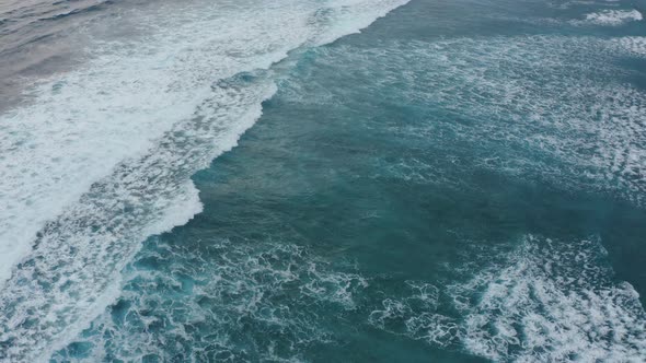 Aerial Top View Powerful Waves on Blue Turquoise Ocean Crashing and Foaming