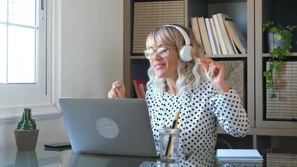 Adult youth woman listen music with laptop computer and dance happy at home