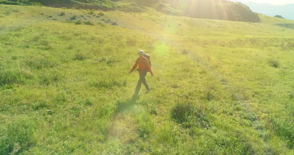 Flight Over Backpack Hiking Tourist Walking Across Green Mountain Field