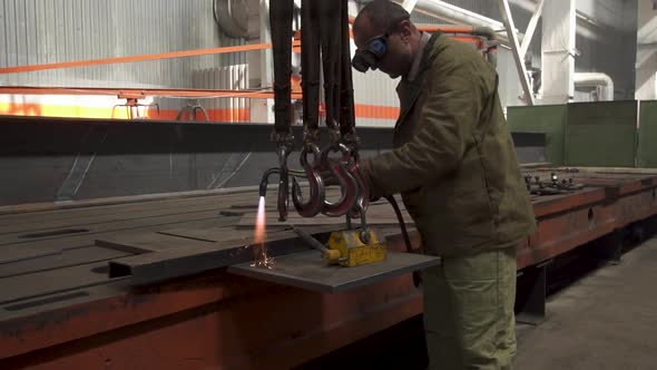 Manual Metal Cutting, Spark Flow and Flame Torch. Protective Masked Welder