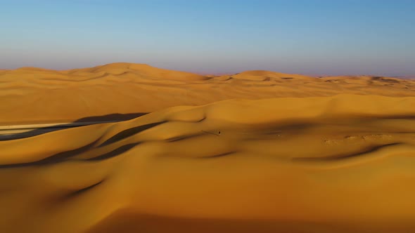 Aerial view of a man walking on dunes during the sunset, U.A.E.