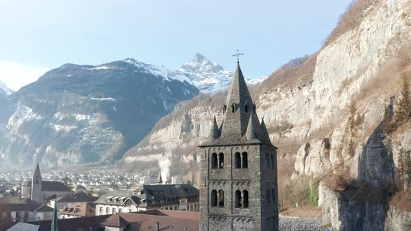 Drone flying away from beautiful old church tower in an idyllic small town