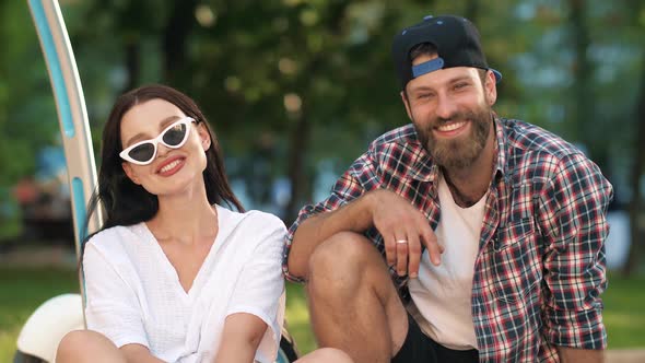 Smiling Man and Woman Sitting at the Grass