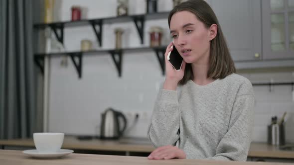 Cheerful Young Woman Talking on Smartphone in Living Room