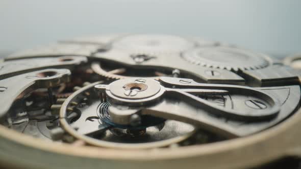 Macro Shot of the Internal Parts of Antique Pocket Watch on a Light Gray Studio Background