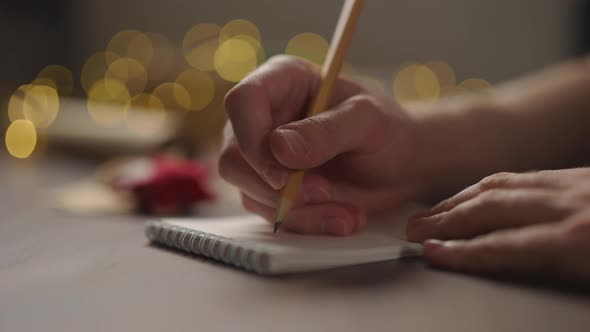 Slow Motion Orbit Shot Man Notepad Pencil Under Warm Light Evening