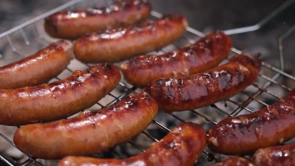 Closeup View of Tasty Sausages Grilling on Charcoal Grill Grate