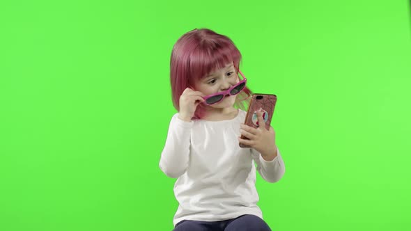 Girl Using Smartphone. Child Emotionally Talking on Mobile Phone, Take Selfie