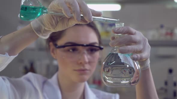 Woman Adding Liquid To Glass Bulb.