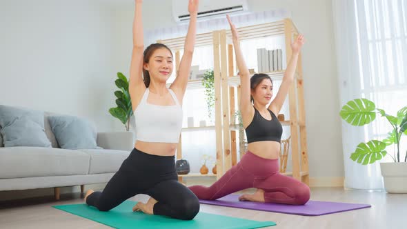 Asian active woman friend doing Yoga Pilates workout together at home.