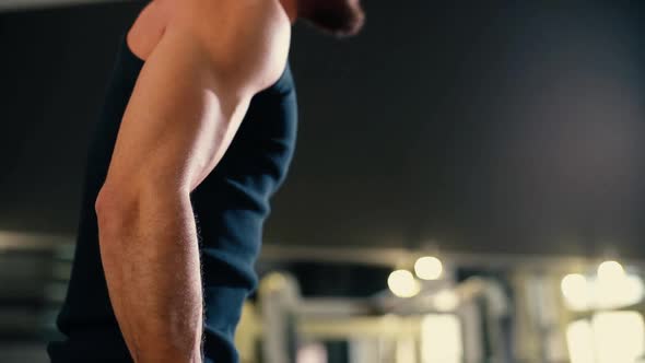 Close-up of Young Man with Muscular Wiry Body Doing Exercise with Weights.