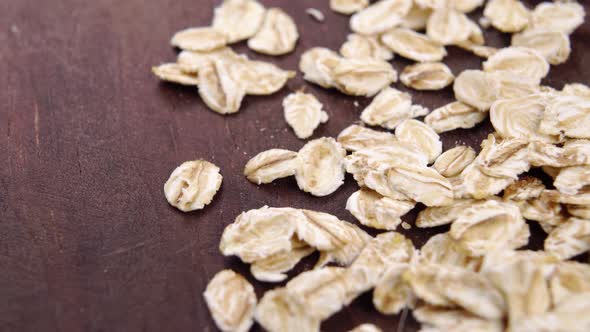 Oat flakes. Uncooked oatmeal on a wooden surface. Rolled whole grains. Macro