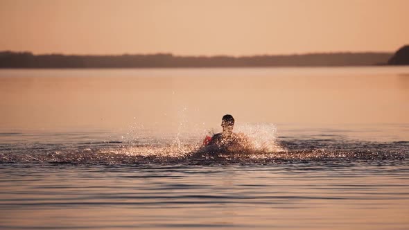 Boy playing in river water. Silhouette of boy playing splash water in river during sunset