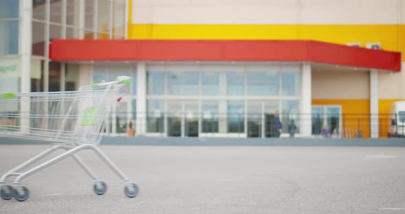 Empty Shopping Cart Rolling at Parking Area Outside Supermarket