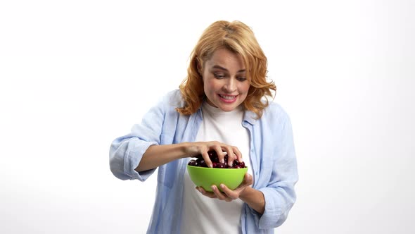 Cheerful Hungry Woman Eating Cherry Bowl with Hunger Berry Vitamin