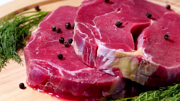 A Piece of Fresh Marbled Beef Steak Rests on a Chopping Board with a Variety of Herbs and Spices to