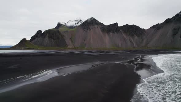 Drone Panning Over Black Sand Beach Sea And Vestrahorn Mountain