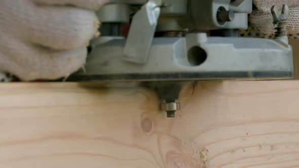 Joiner Cuts Off the Sharp Corners of Wooden Beam with Milling Machine Close-up