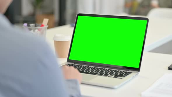 Rear View of African Woman Using Laptop with Green Chroma Key Screen