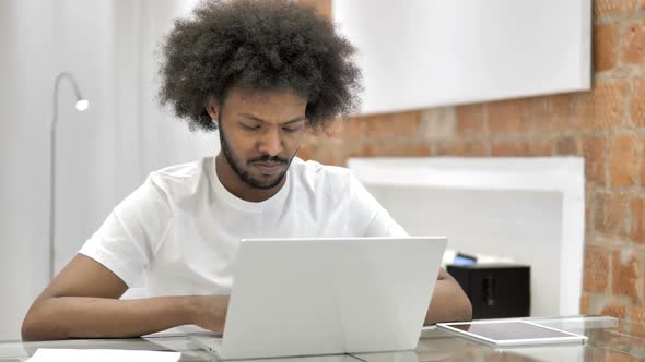 Tense African Man Working on Laptop