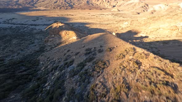 FPV Drone Flying Close Over a Desert Like Landscape with a Mountain Volcano in the Background