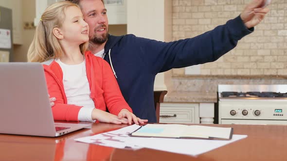 Smiling father and daughter sitting on chair taking selfie 4K 4k