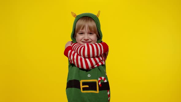 Kid Teen Girl in Christmas Elf Santa Helper Costume Blows Air Kisses at Camera Hugging Embracing