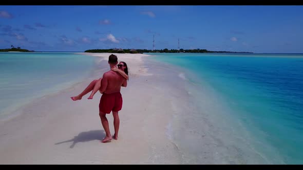 Romantic couple posing on beautiful lagoon beach lifestyle by blue green ocean and white sandy backg