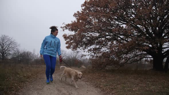 Pretty Fitness Woman and Dog Jooging in Fresh Air