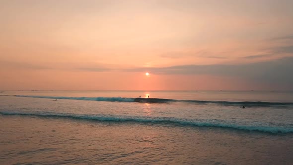 Two Young Women Enjoying an Incredible Orange Sunset in the Ocean. 