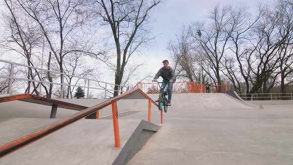 BMX Rider Doing Tricks in Cocncrete Skatepark