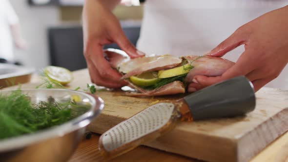 Caucasian female chef preparing a dish and smiling in a kitchen