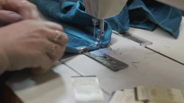 Fabric Produciton Worker at Her Workplace Working with a Sewing Machine Making Clothes and Fabrics