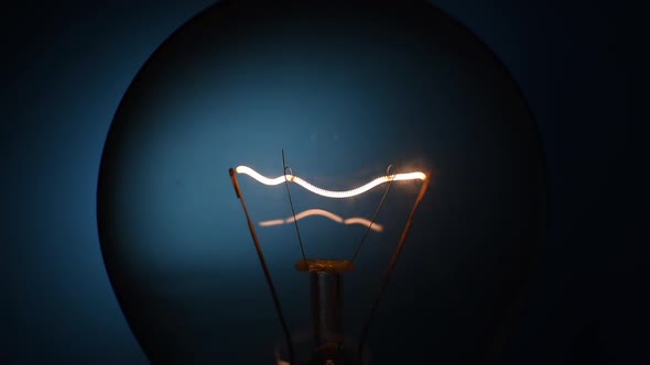 Closeup Incandescent Lamp Flashes on a Dark Background