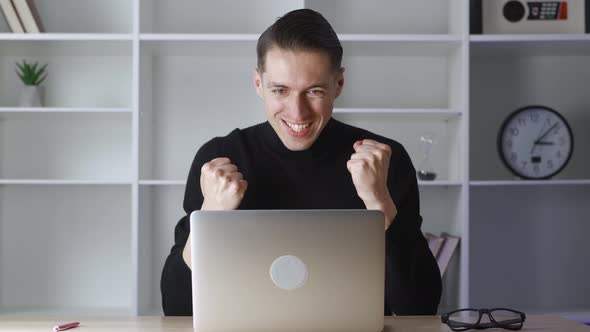 Successful Business Man Sits at Table with Laptop Working at Office