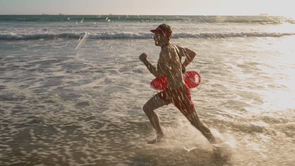 Male lifeguard running along the beach