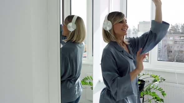 Portrait of cheerful european woman in headphones listening to music, beautiful girl singing