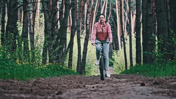 Young Woman on a Bicycle Rides Along a Forest Path in Summer Day Slow Motion