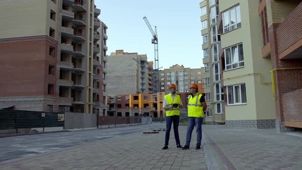 Far Front View of Two Builders That Talk to Each Other