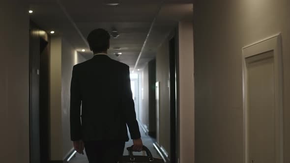 Man Walking with Luggage to Hotel Room