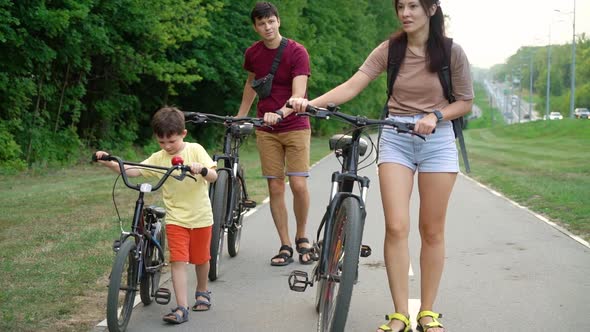 Family Walking with Bicycles Near Forest