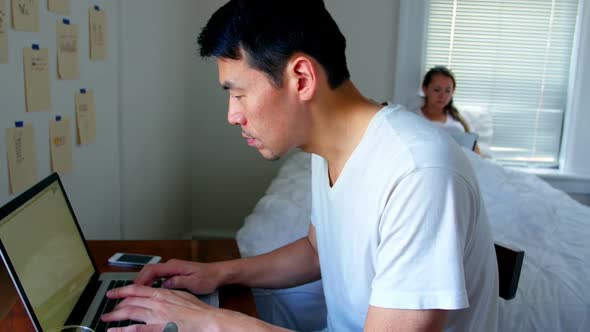 Man using laptop while woman using digital tablet