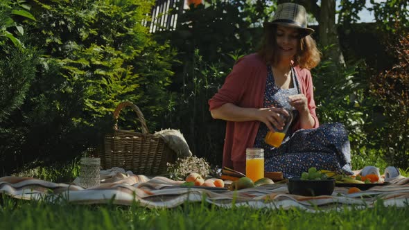 Young Woman Having Summer Picnic in Backyard