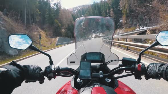 Motorcyclist Rides on Beautiful Landscape Mountain Road Near Snowy Switzerland Alps