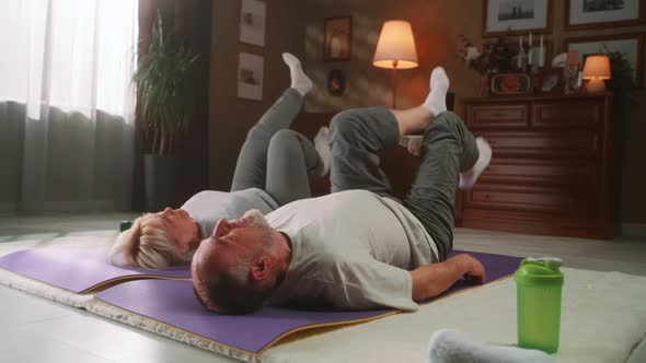 Aged Couple Exercising on a Fitness Mat